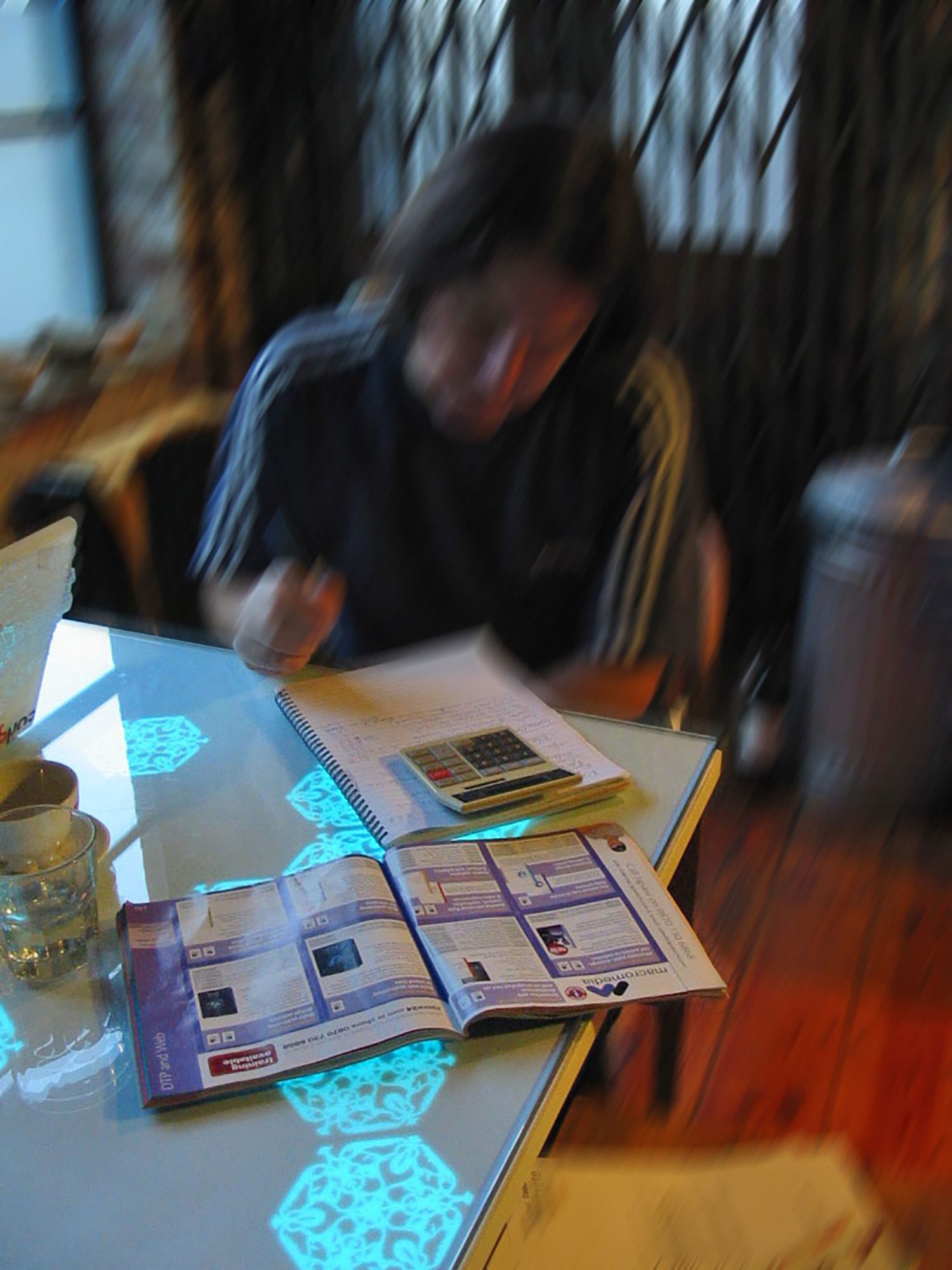 A blurred photograph of a participant sitting at their kitchen table with the History Tablecloth illuminated various items on the surface